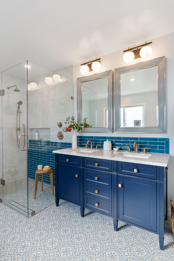 Пример оригинального дизайна: главная ванная комната среднего размера в стиле неоклассика (современная классика) с фасадами островного типа, синими фасадами, накладной ванной, угловым душем, биде, синей плиткой, керамической плиткой, белыми стенами, полом из мозаичной плитки, врезной раковиной, мраморной столешницей, серым полом, душем с распашными дверями, белой столешницей, тумбой под две раковины, встроенной тумбой и кессонным потолком