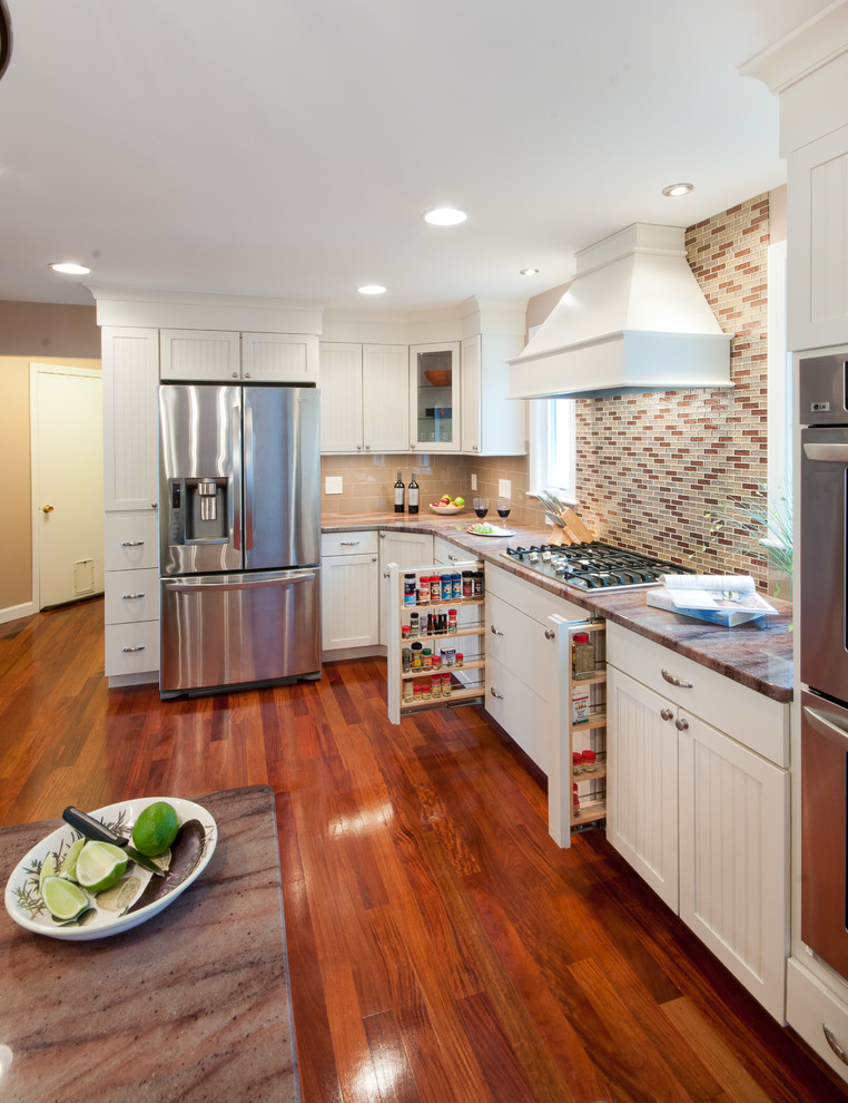 This is an example of a large traditional u-shaped eat-in kitchen in Providence with an undermount sink, shaker cabinets, white cabinets, granite benchtops, beige splashback, subway tile splashback, stainless steel appliances, a peninsula and medium hardwood floors.