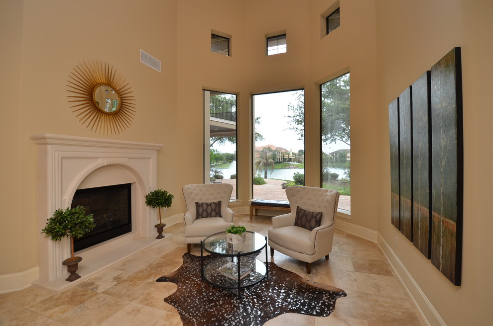 This is an example of a mid-sized transitional formal enclosed living room in Houston with beige walls, travertine floors, a standard fireplace, a stone fireplace surround, beige floor and no tv.