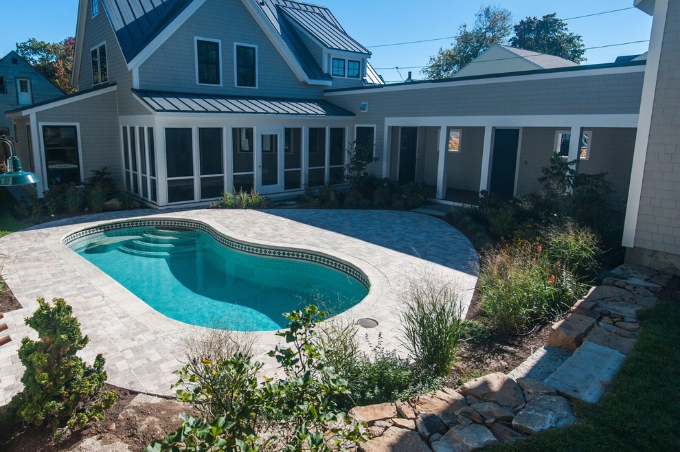 Photo of a small modern backyard kidney-shaped pool in Portland Maine with brick pavers.