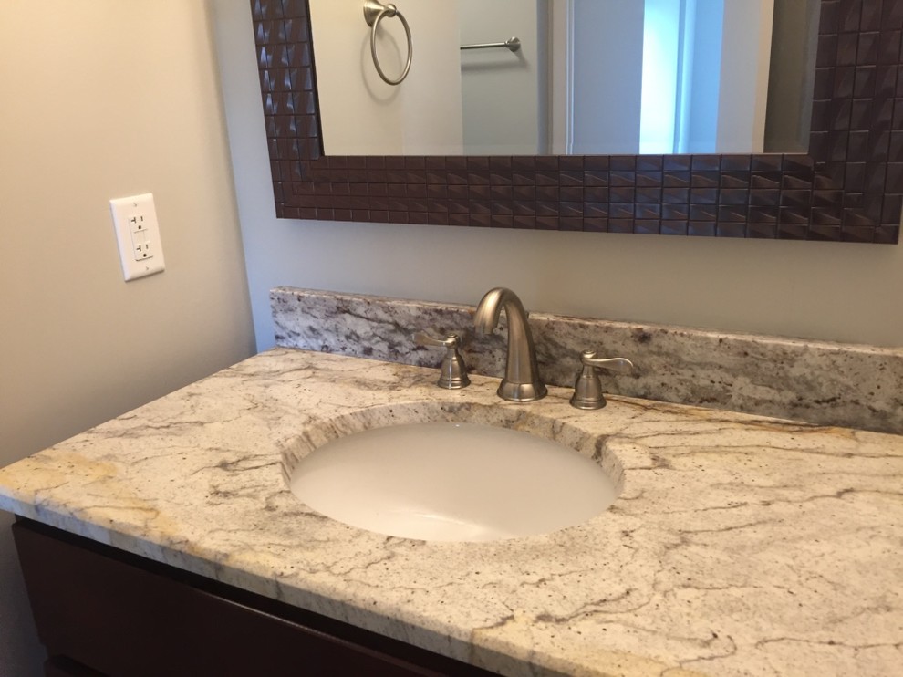 Inspiration for a mid-sized transitional 3/4 bathroom in Cleveland with dark wood cabinets, engineered quartz benchtops, an alcove shower, black tile, porcelain tile, beige walls and an undermount sink.