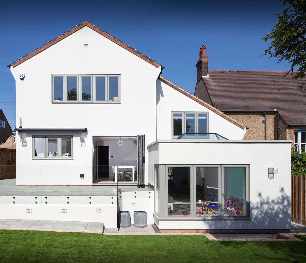 Inspiration for a large traditional three-storey stucco white exterior in Hertfordshire with a gable roof.