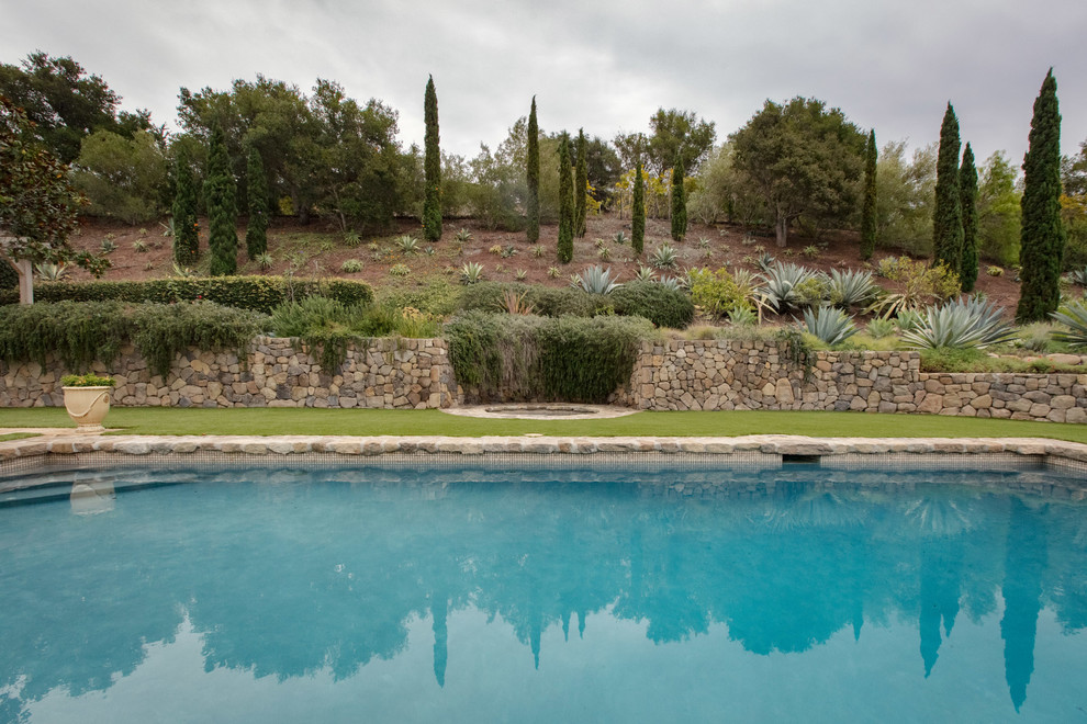 This is an example of a large mediterranean backyard rectangular pool in Santa Barbara with natural stone pavers.