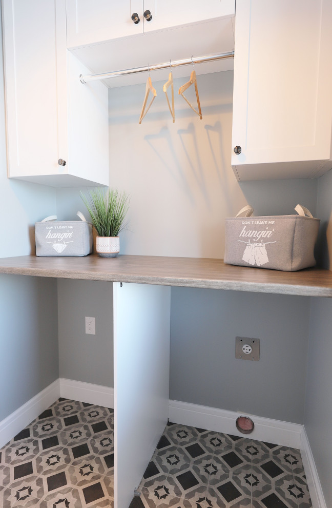 Inspiration for a small country single-wall dedicated laundry room in Other with shaker cabinets, white cabinets, laminate benchtops, ceramic floors, a side-by-side washer and dryer, multi-coloured floor and grey benchtop.