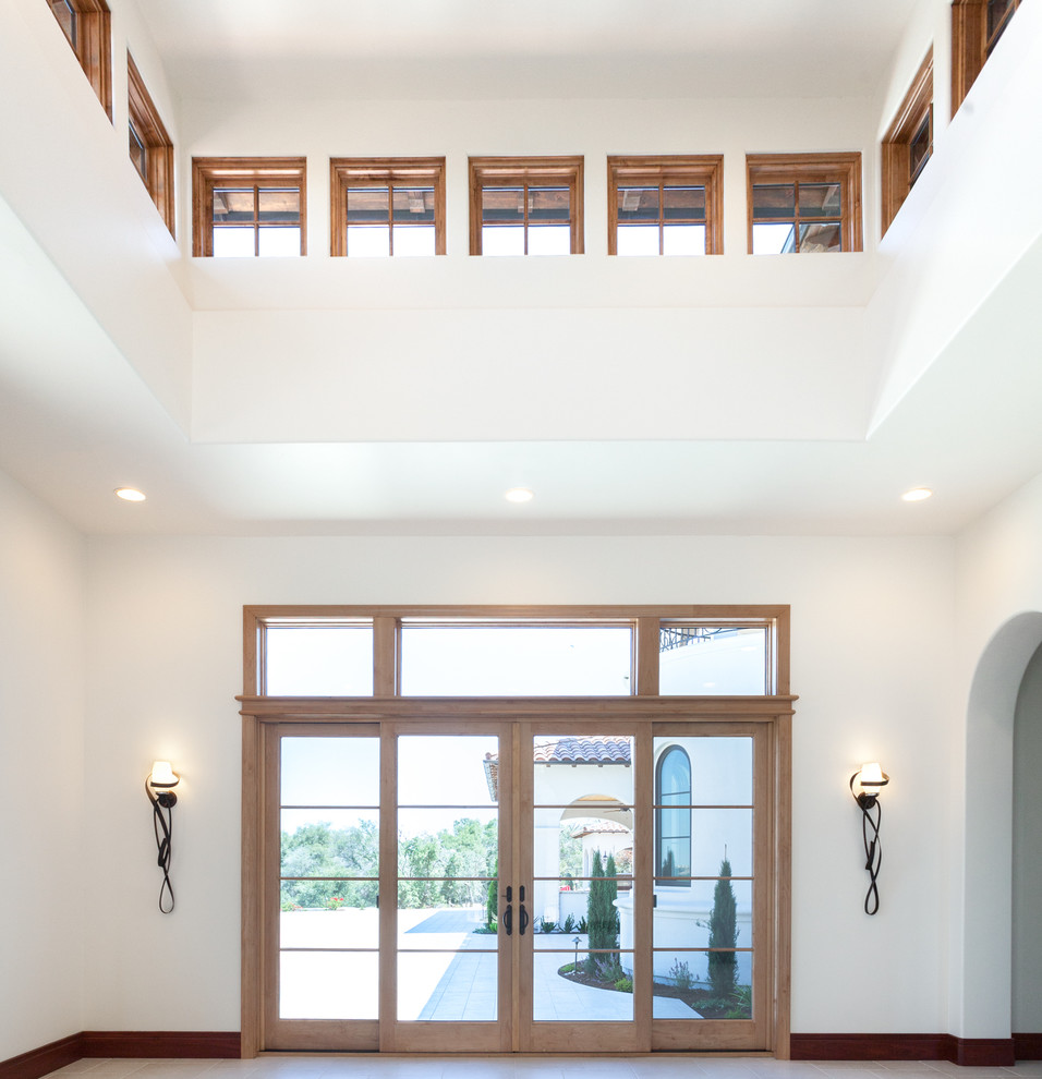 Inspiration for a large mediterranean entry hall in Sacramento with white walls, ceramic floors and a single front door.