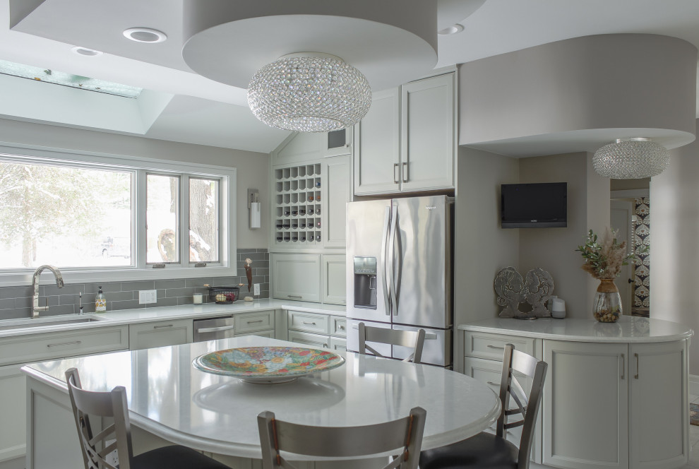 Inspiration for a large transitional u-shaped porcelain tile and gray floor eat-in kitchen remodel with an undermount sink, recessed-panel cabinets, gray cabinets, quartz countertops, gray backsplash, glass tile backsplash, stainless steel appliances, an island and white countertops