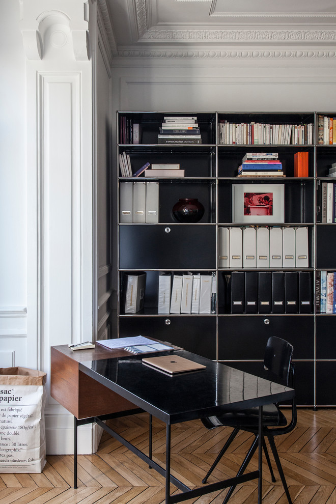 Inspiration for a contemporary home office in Paris with white walls, light hardwood floors, no fireplace and a freestanding desk.