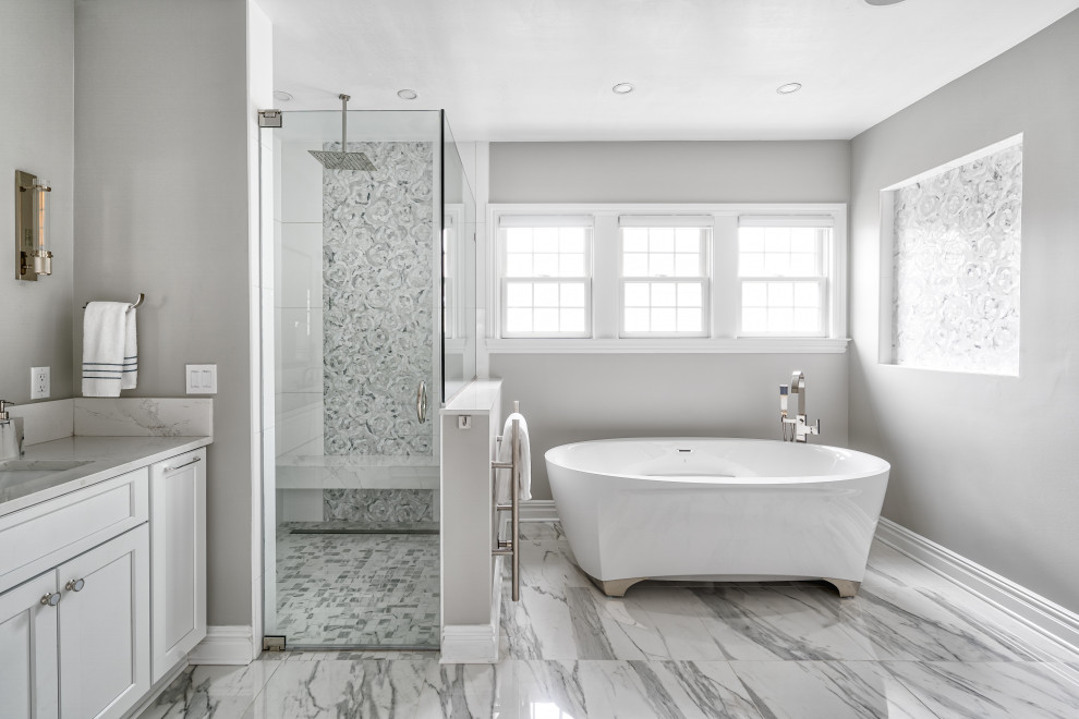 Design ideas for an expansive transitional master bathroom in New York with shaker cabinets, white cabinets, a freestanding tub, a curbless shower, a bidet, white tile, porcelain tile, beige walls, marble floors, an undermount sink, quartzite benchtops, a hinged shower door and white benchtops.