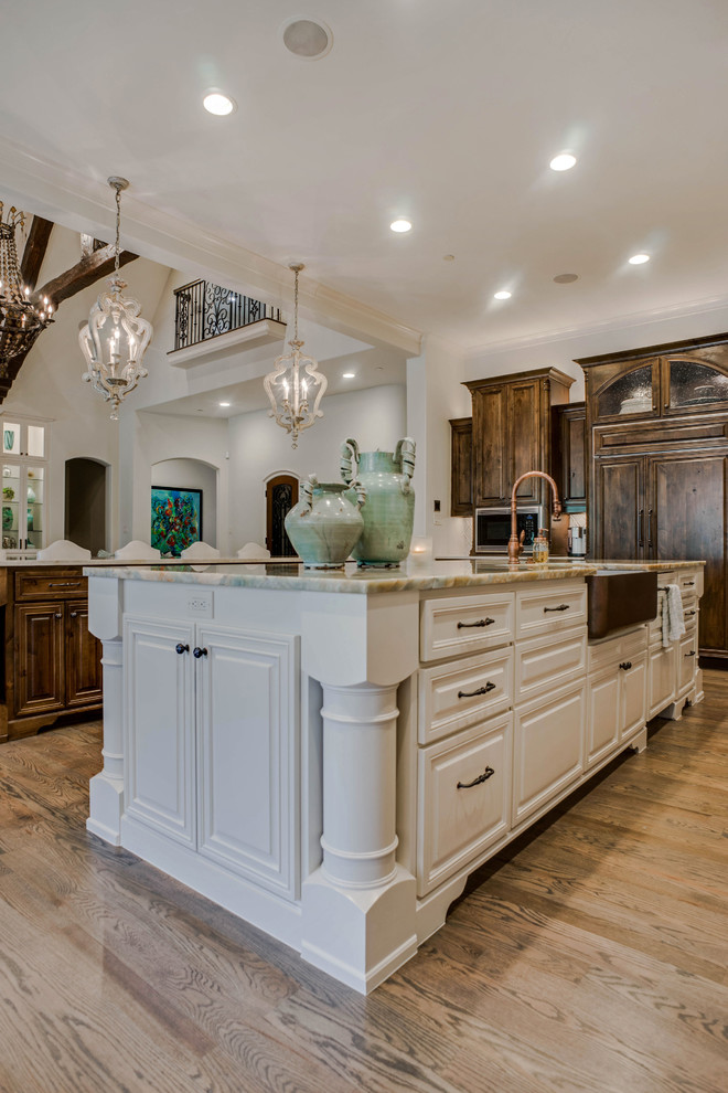 Inspiration for a large traditional u-shaped open plan kitchen in Dallas with a farmhouse sink, recessed-panel cabinets, dark wood cabinets, quartzite benchtops, blue splashback, ceramic splashback, panelled appliances, medium hardwood floors, multiple islands, brown floor and blue benchtop.