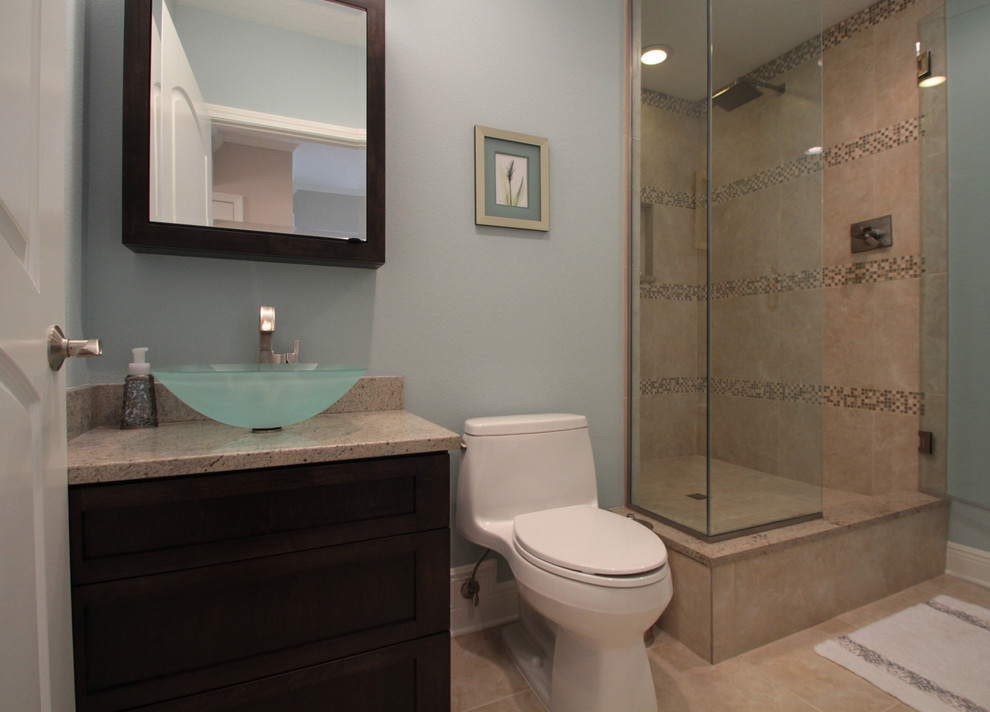 Large beach style 3/4 bathroom in Tampa with shaker cabinets, dark wood cabinets, a freestanding tub, matchstick tile, beige walls, vinyl floors, a vessel sink, granite benchtops, a corner shower, a one-piece toilet, beige floor and a hinged shower door.