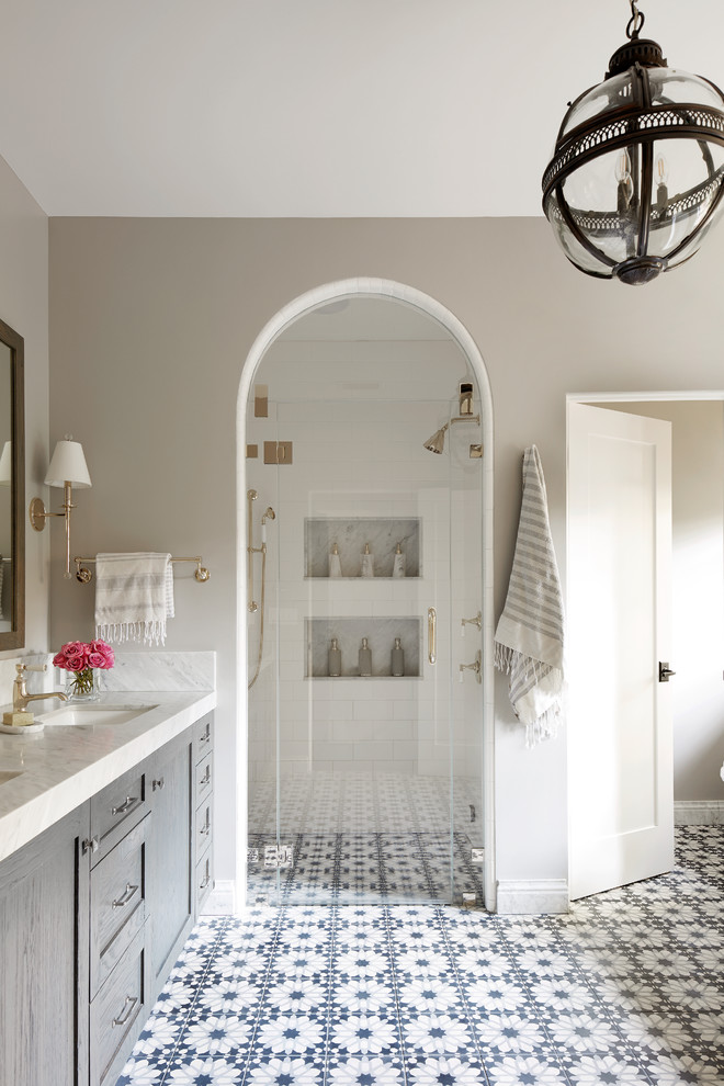 Design ideas for a mediterranean master bathroom in San Francisco with shaker cabinets, grey cabinets, an alcove shower, white tile, subway tile, grey walls, cement tiles, an undermount sink, multi-coloured floor, a hinged shower door and white benchtops.
