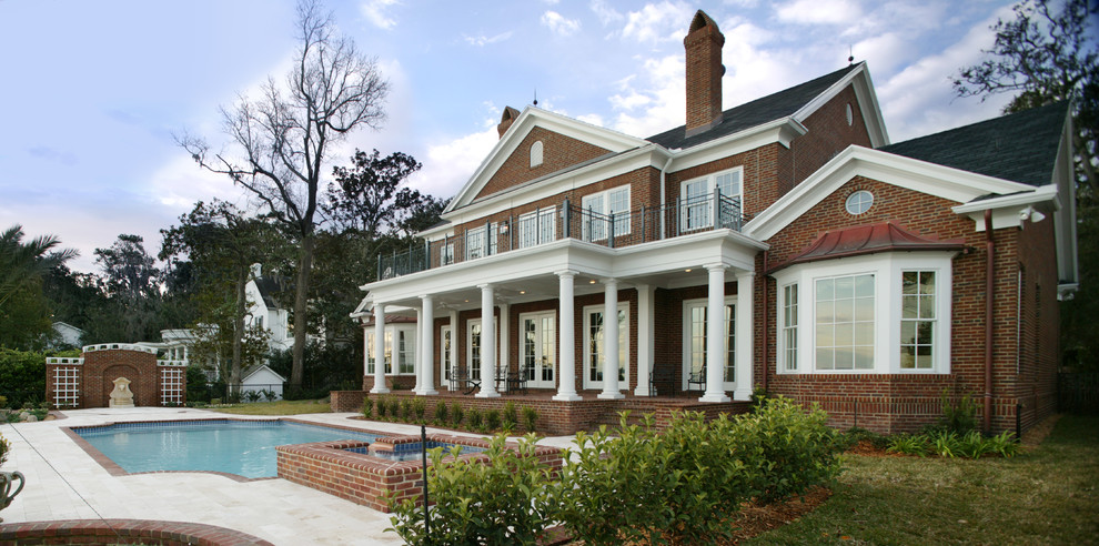 Large traditional two-storey brick red exterior in Jacksonville with a gable roof.