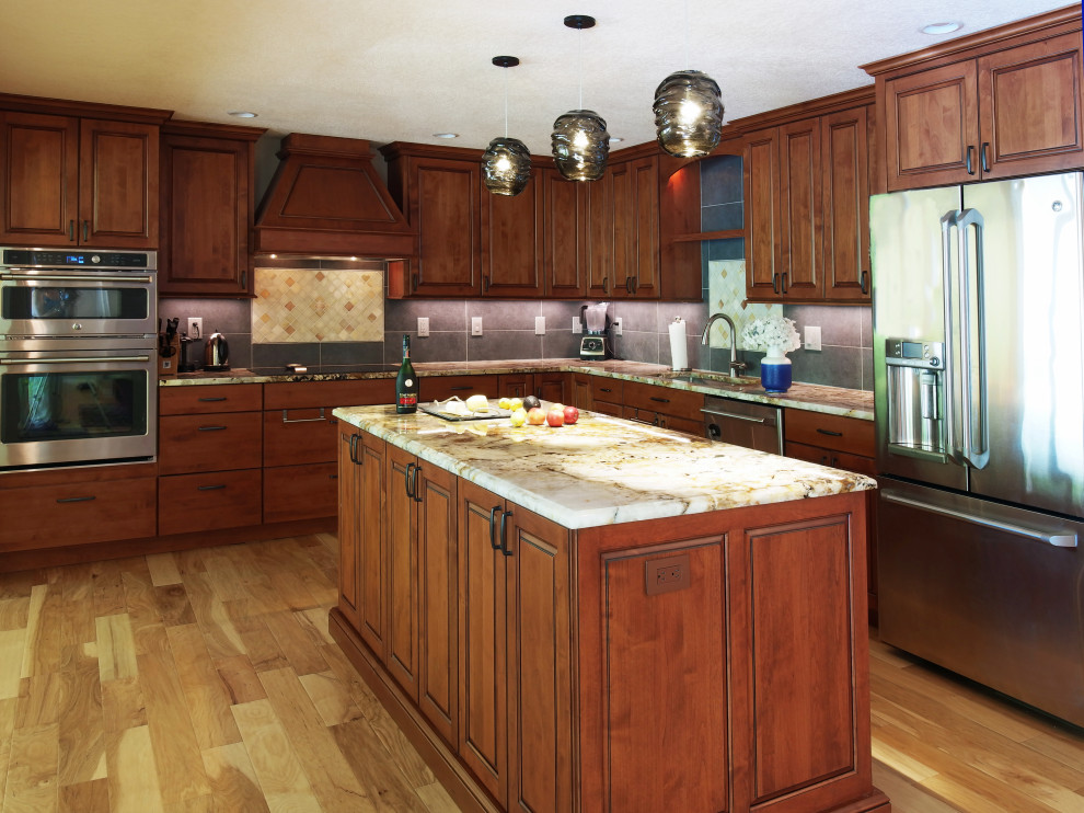 Example of a mid-sized transitional l-shaped medium tone wood floor and yellow floor open concept kitchen design with a single-bowl sink, raised-panel cabinets, medium tone wood cabinets, granite countertops, gray backsplash, porcelain backsplash, stainless steel appliances, an island and multicolored countertops