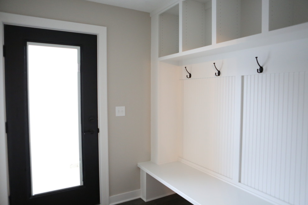 This is an example of a large transitional mudroom in Minneapolis with grey walls, dark hardwood floors, a single front door and a black front door.
