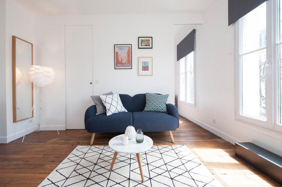 This is an example of a mid-sized contemporary formal open concept living room in Paris with white walls, medium hardwood floors and no fireplace.