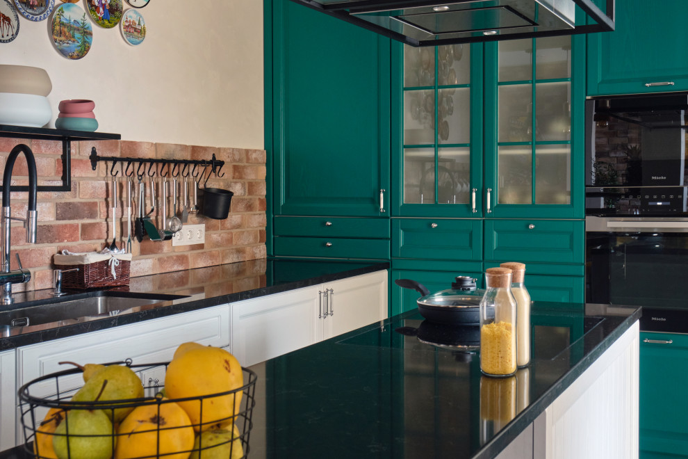 Inredning av ett industriellt mellanstort brun brunt kök, med en enkel diskho, luckor med upphöjd panel, gröna skåp, bänkskiva i kvarts, brunt stänkskydd, stänkskydd i tegel, svarta vitvaror, klinkergolv i keramik, en köksö och orange golv