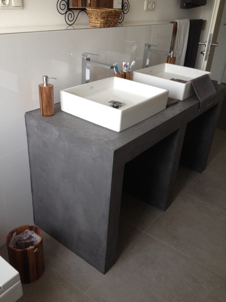 Duschbad With grauen Schränken, Wandtoilette, weißer Wandfarbe, Aufsatzwaschbecken, Beton-Waschbecken/Waschtisch, grauem Boden and Falttür-Duschabtrennung in Cologne