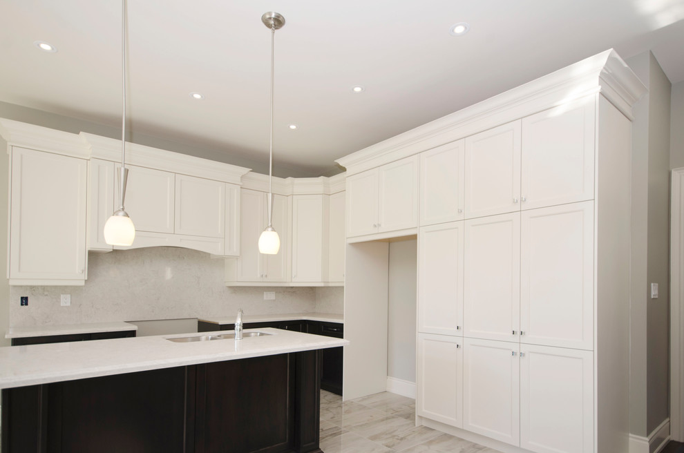 Example of a mid-sized transitional l-shaped porcelain tile kitchen design in Toronto with a double-bowl sink, shaker cabinets, white cabinets, white backsplash, marble backsplash, stainless steel appliances and an island