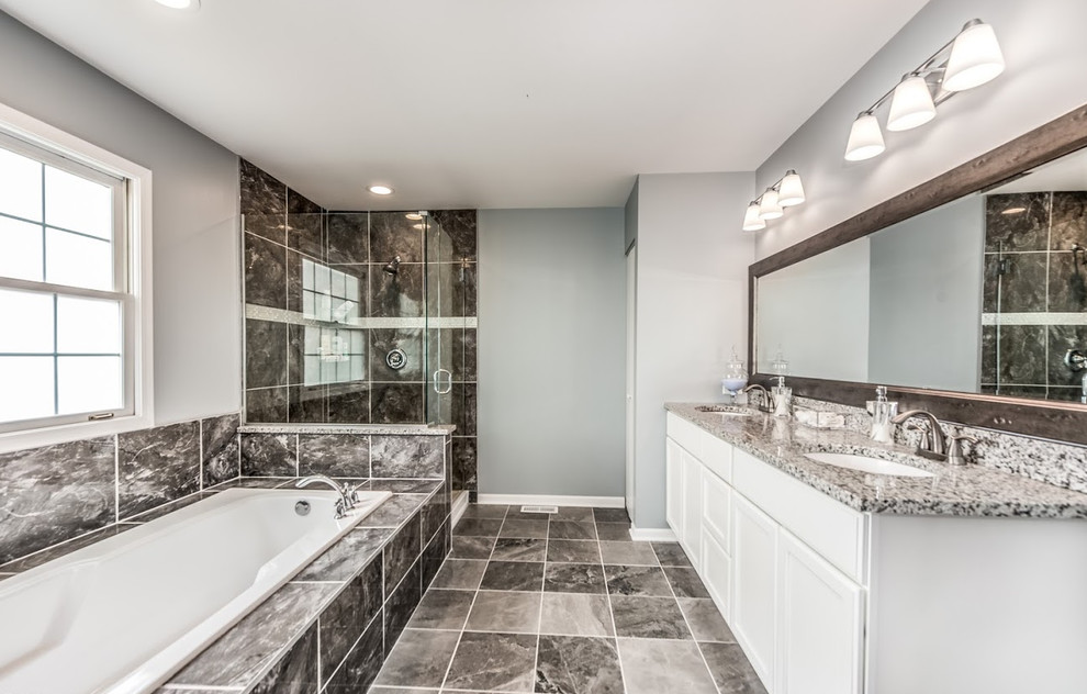 Design ideas for a large transitional master bathroom in Chicago with recessed-panel cabinets, white cabinets, a drop-in tub, an alcove shower, a one-piece toilet, black tile, grey walls, an undermount sink, terrazzo benchtops, black floor and an open shower.