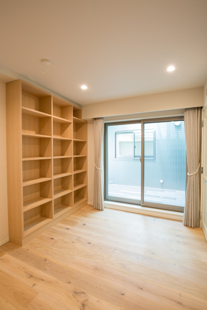 This is an example of a mid-sized contemporary home yoga studio in Tokyo with white walls, plywood floors and beige floor.