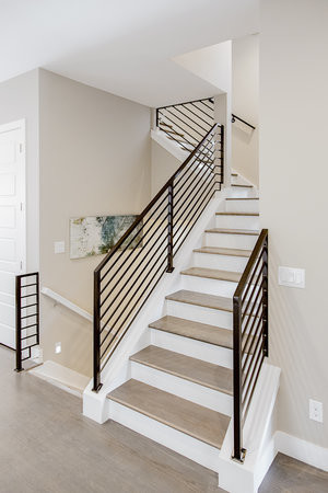 Mid-sized contemporary wood straight staircase in Denver with painted wood risers and metal railing.