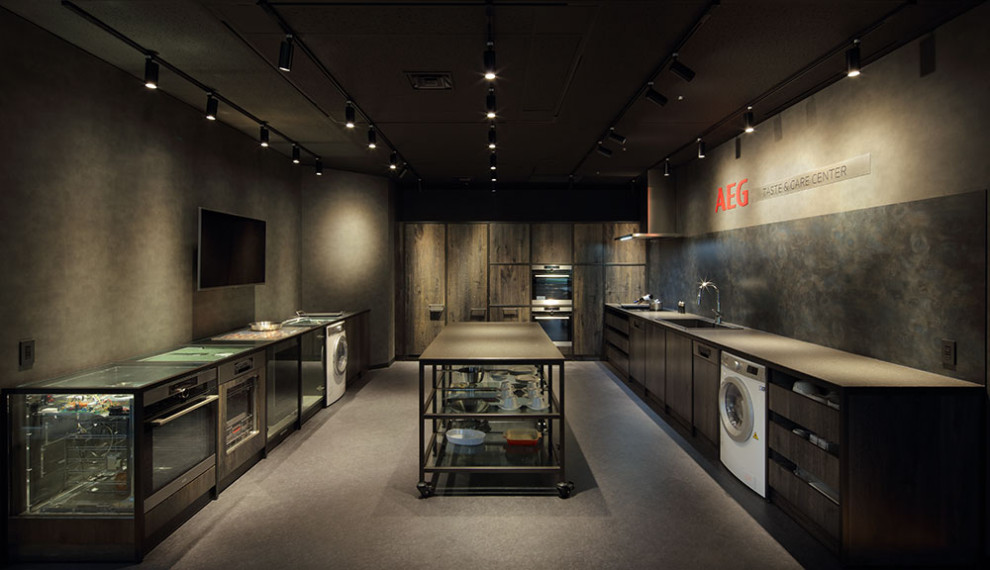 東京23区にある小さなインダストリアルスタイルのおしゃれなキッチン (ドロップインシンク、インセット扉のキャビネット、黒いキャビネット、クオーツストーンカウンター、黒いキッチンパネル、木材のキッチンパネル、クッションフロア、グレーの床、黒いキッチンカウンター) の写真
