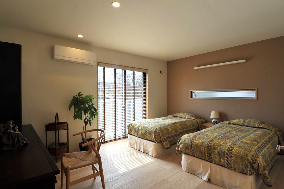 This is an example of a mid-sized contemporary master bedroom in Other with brown walls, plywood floors and beige floor.