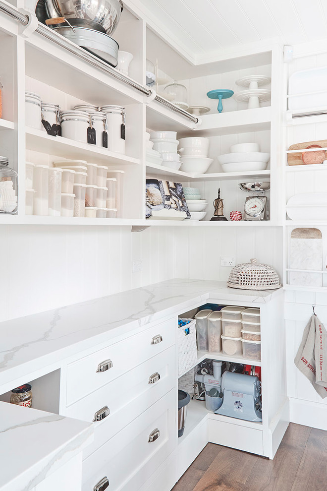 This is an example of a mid-sized country u-shaped kitchen pantry in Sydney with a farmhouse sink, shaker cabinets, white cabinets, marble benchtops, white splashback, subway tile splashback, stainless steel appliances, light hardwood floors and with island.