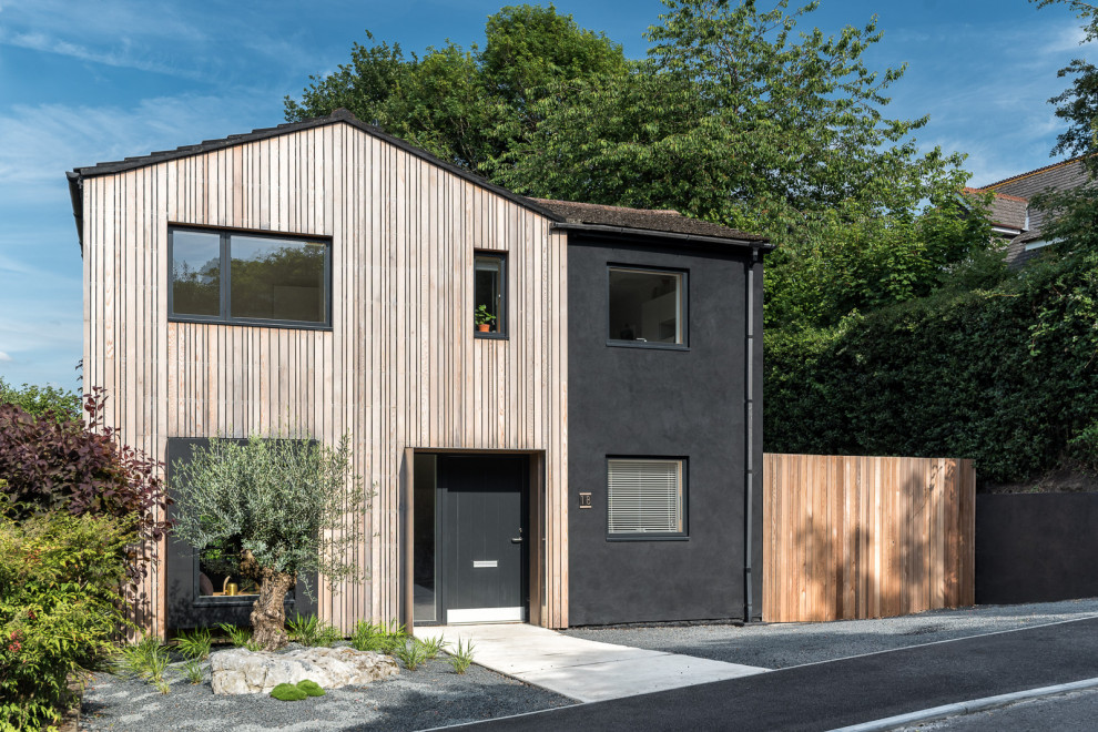Mittelgroßes, Zweistöckiges Skandinavisches Haus mit brauner Fassadenfarbe, Satteldach, Ziegeldach, rotem Dach und Wandpaneelen in Surrey