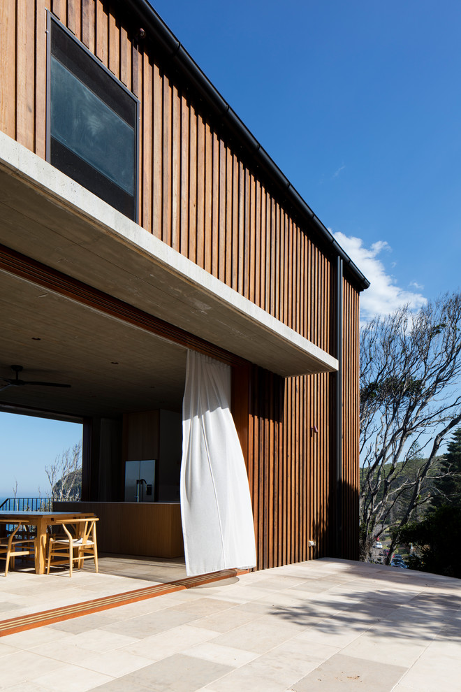 Inspiration for a mid-sized beach style two-storey brown house exterior in Los Angeles with wood siding, a flat roof and a metal roof.