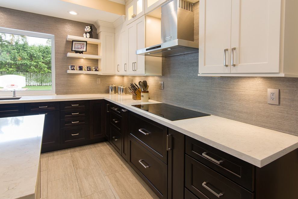 Photo of a large u-shaped eat-in kitchen in Miami with an undermount sink, shaker cabinets, dark wood cabinets, quartz benchtops, grey splashback, porcelain splashback, stainless steel appliances, with island and beige benchtop.