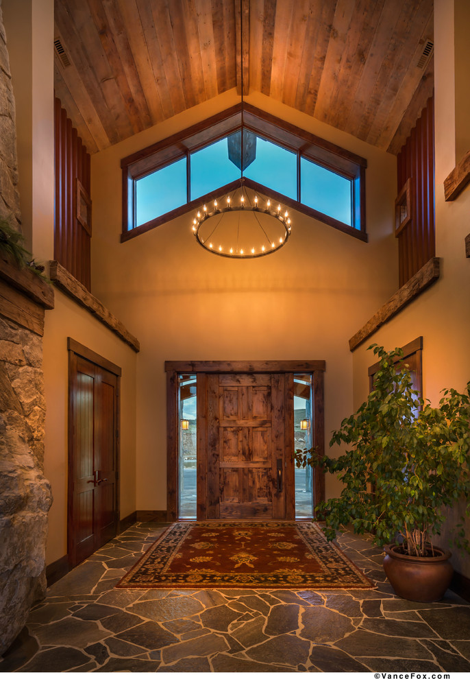 Inspiration for a large rustic slate floor foyer remodel with yellow walls and a medium wood front door
