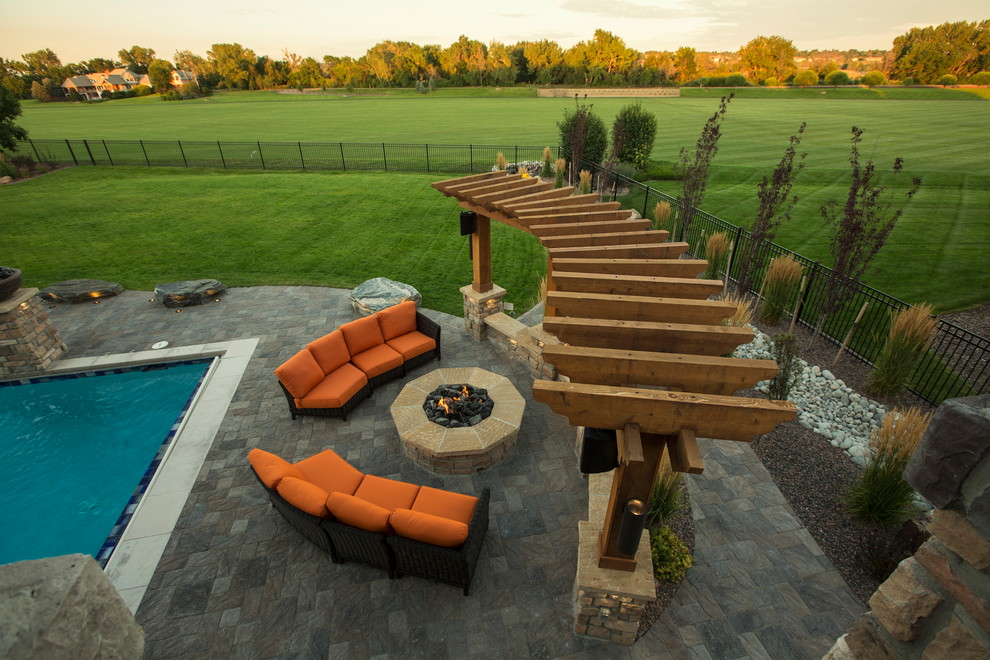 Inspiration for a mid-sized country backyard patio in Denver with a fire feature, concrete pavers and a pergola.