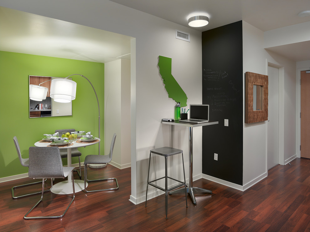 This is an example of a contemporary dining room in San Francisco with green walls and dark hardwood floors.