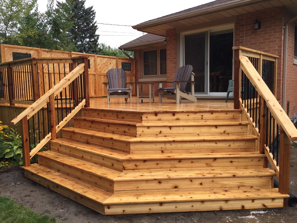 Design ideas for a traditional backyard deck in Toronto with a roof extension.