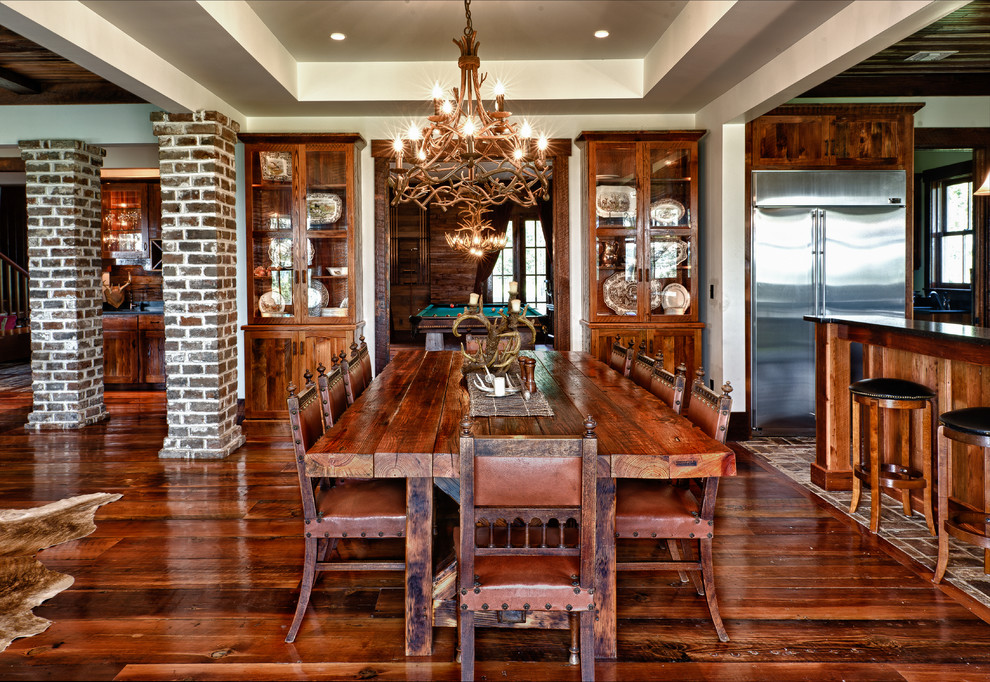 Country open plan dining in Charleston with beige walls, dark hardwood floors and brown floor.