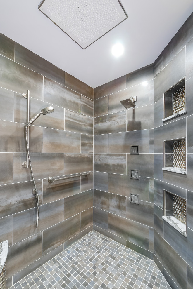This is an example of an expansive transitional master bathroom in Cleveland with raised-panel cabinets, grey cabinets, a claw-foot tub, an open shower, a two-piece toilet, multi-coloured tile, porcelain tile, beige walls, porcelain floors, a vessel sink, engineered quartz benchtops, grey floor, a hinged shower door and grey benchtops.