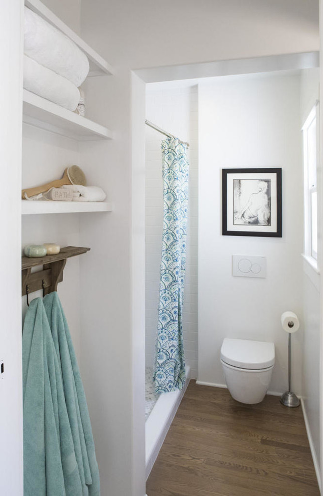 This is an example of a small country 3/4 bathroom in Santa Barbara with recessed-panel cabinets, white cabinets, a drop-in tub, white tile, subway tile, white walls, medium hardwood floors and a pedestal sink.