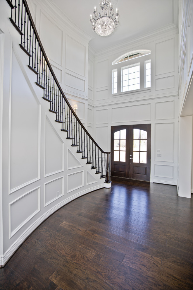 This is an example of an expansive transitional front door in Other with white walls, dark hardwood floors, a double front door, a dark wood front door and brown floor.