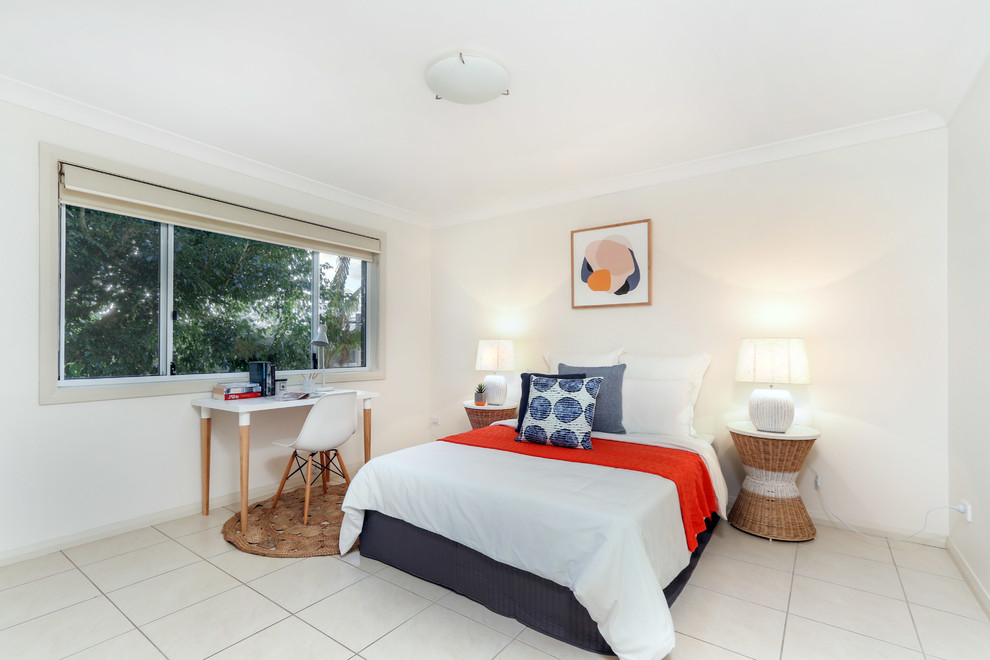 Inspiration for a beach style guest bedroom in Sydney with beige walls and beige floor.