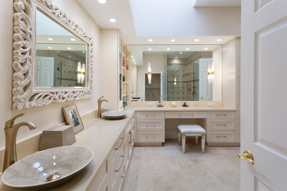 Inspiration for a large transitional master beige tile and mosaic tile porcelain tile and beige floor alcove shower remodel in Miami with shaker cabinets, beige cabinets, a one-piece toilet, beige walls, a vessel sink, solid surface countertops, a hinged shower door and beige countertops