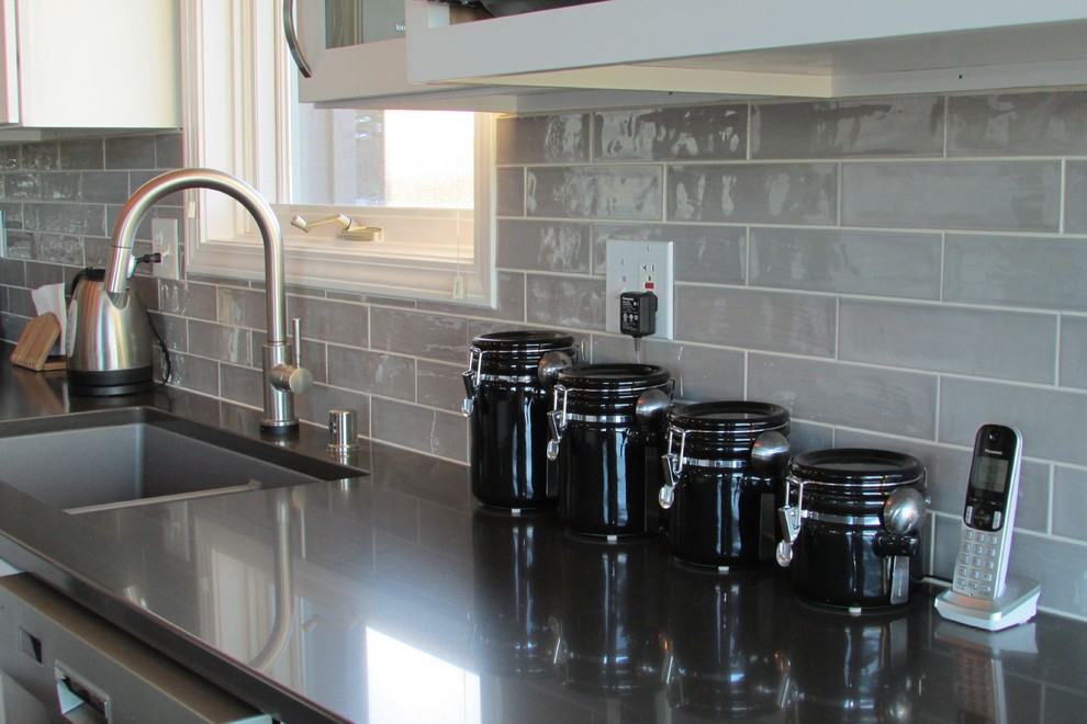 Inspiration for a mid-sized transitional l-shaped medium tone wood floor and brown floor eat-in kitchen remodel with a double-bowl sink, recessed-panel cabinets, white cabinets, gray backsplash, stainless steel appliances, an island and subway tile backsplash
