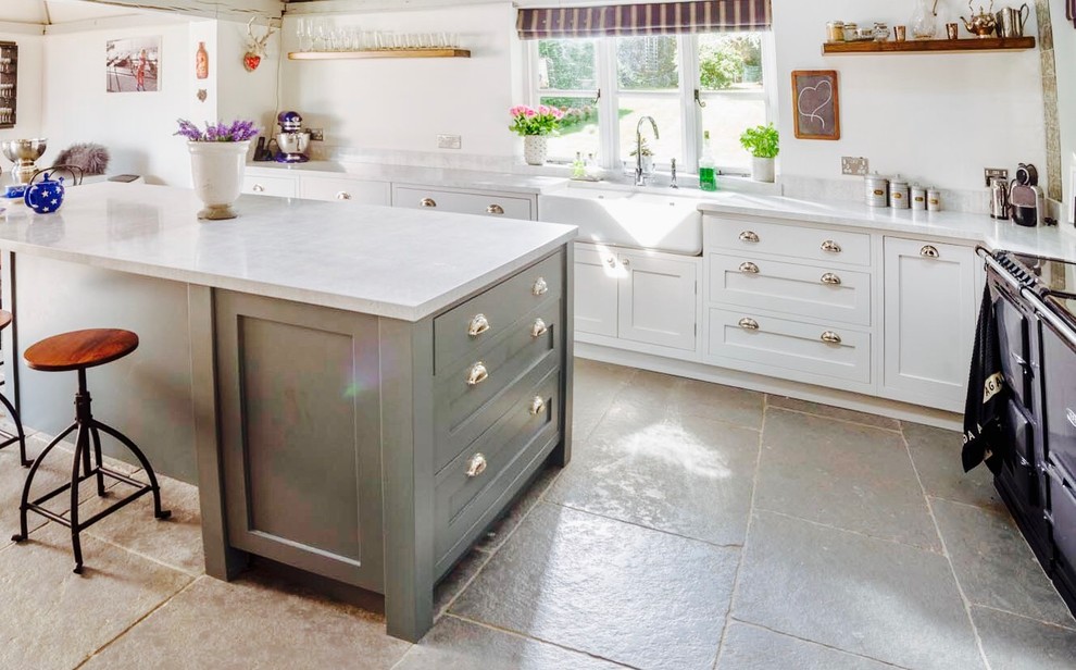 This is an example of a mid-sized country l-shaped separate kitchen in Other with a farmhouse sink, shaker cabinets, white cabinets, marble benchtops, slate floors and with island.