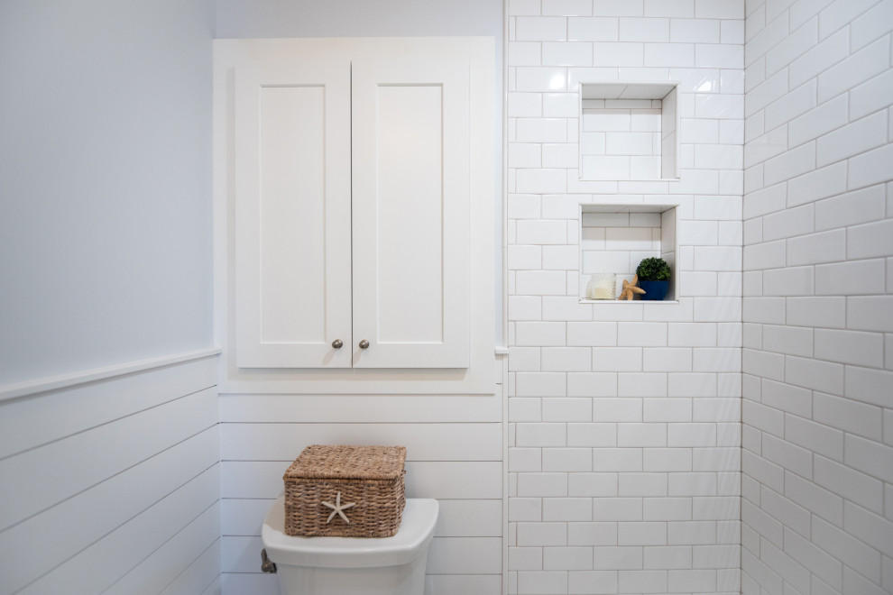 Идея дизайна: маленькая главная ванная комната в морском стиле с фасадами в стиле шейкер, белыми фасадами, ванной в нише, душем над ванной, раздельным унитазом, серой плиткой, каменной плиткой, полом из керамической плитки, врезной раковиной, столешницей из искусственного кварца, шторкой для ванной, белой столешницей, нишей, тумбой под одну раковину, встроенной тумбой и стенами из вагонки для на участке и в саду