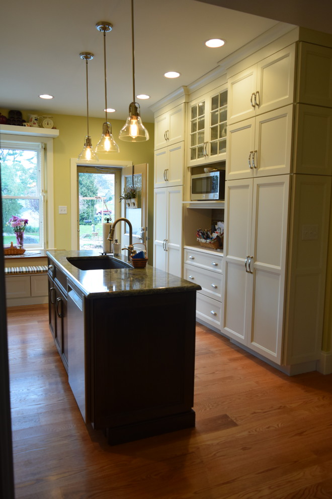 Inspiration for a transitional medium tone wood floor kitchen remodel with an undermount sink, shaker cabinets, white cabinets, quartz countertops, stainless steel appliances and an island