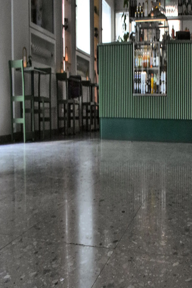 На фото: огромный коридор в стиле модернизм с белыми стенами, полом из терраццо и серым полом