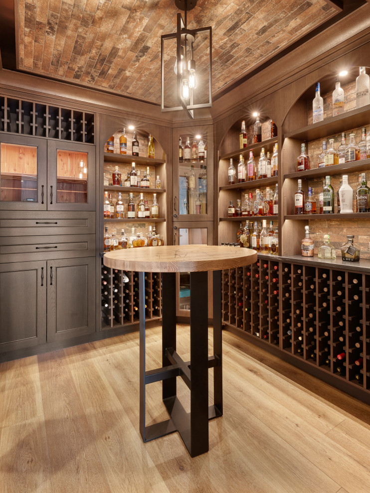 Large transitional wine cellar in Edmonton with light hardwood floors, display racks and brown floor.