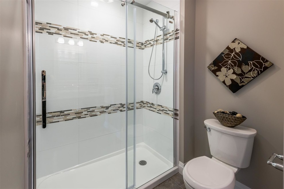 Inspiration for a mid-sized transitional 3/4 porcelain tile and brown floor alcove shower remodel with shaker cabinets, dark wood cabinets, a two-piece toilet, gray walls, a vessel sink, limestone countertops and beige countertops