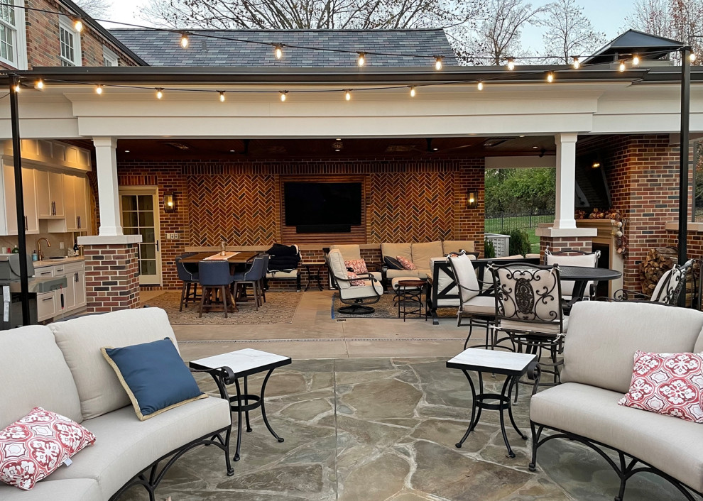 Photo of a large transitional patio in St Louis with an outdoor kitchen, concrete slab and a roof extension.