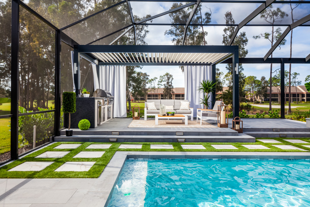 Cette image montre une terrasse arrière minimaliste de taille moyenne avec une cuisine d'été, du carrelage et une pergola.